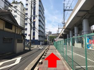 緑のフェンスと道の写真