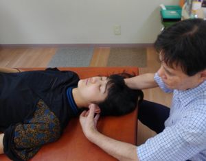 女性の患者に施術をする院長の写真